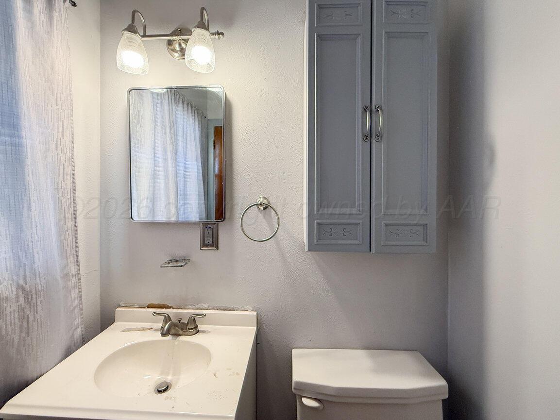 4305 South Bonham Street Amarillo, TX 79110 - Photo 40 of 48 a bathroom with a sink a toilet and mirror