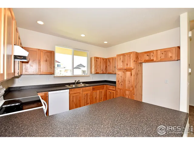 a kitchen with stainless steel appliances granite countertop a sink a stove and a refrigerator