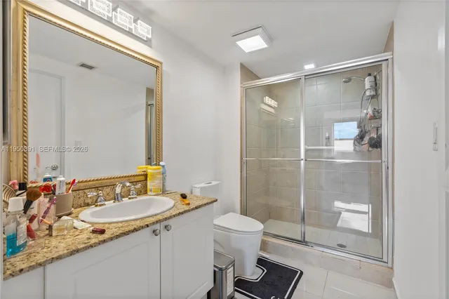 a bathroom with a granite countertop sink toilet and shower