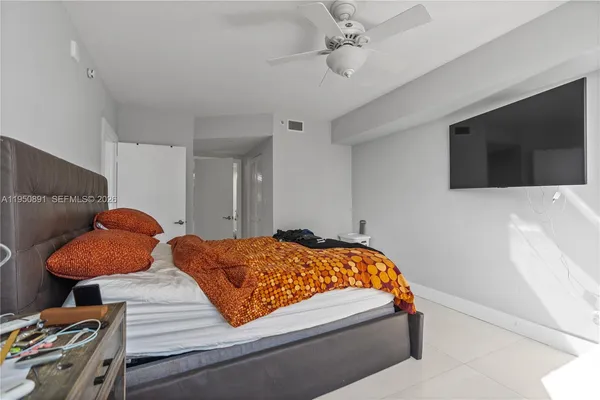 a bedroom with bed and flat screen tv