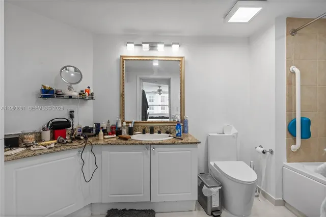 a bathroom with a toilet sink vanity and mirror