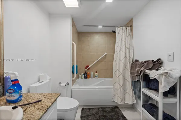 a bathroom with a granite countertop toilet and a shower
