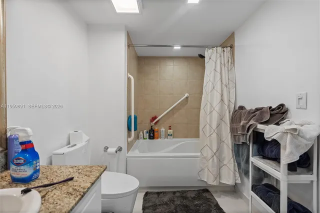 a bathroom with a granite countertop toilet and a shower