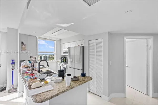 a kitchen with stainless steel appliances granite countertop a sink and a refrigerator