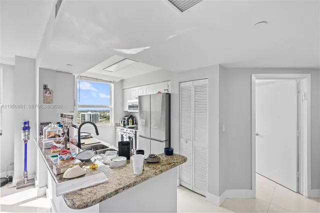 a kitchen with stainless steel appliances granite countertop a sink and a refrigerator