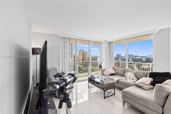a living room with furniture and floor to ceiling window