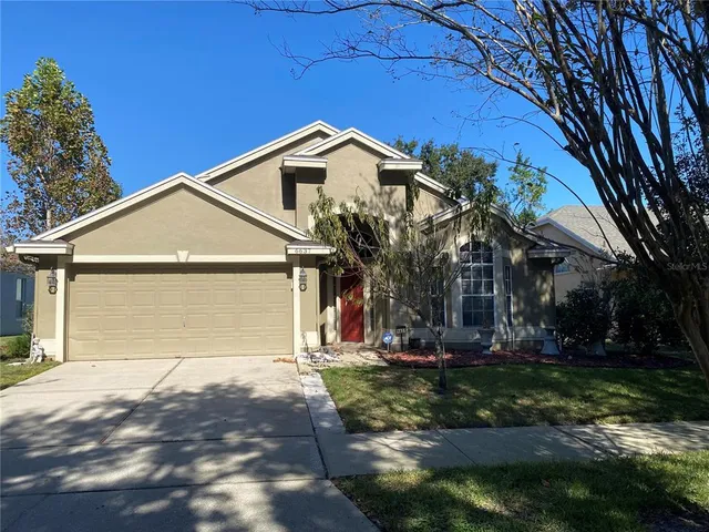 a view of a house with a yard and potted plants