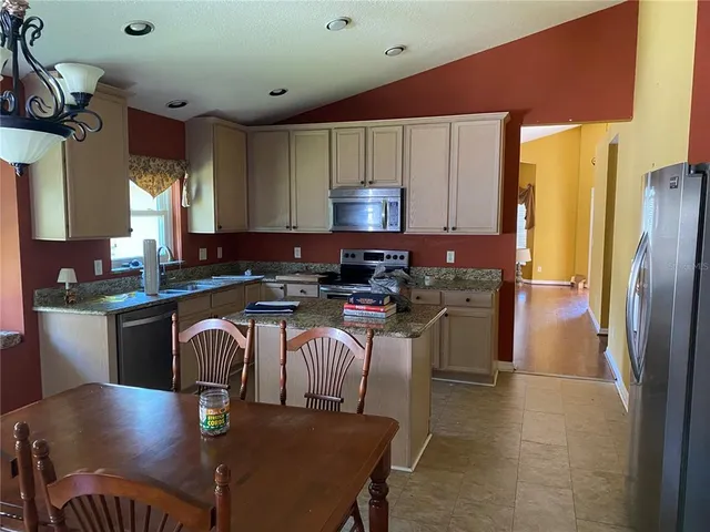 a kitchen with stainless steel appliances granite countertop a sink refrigerator and microwave