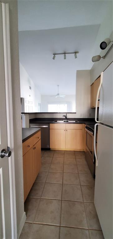 3584 Kings Road, Unit 101 Palm Harbor, FL 34685 - Photo 11 of 17 a kitchen with granite countertop a sink a counter top space and stainless steel appliances