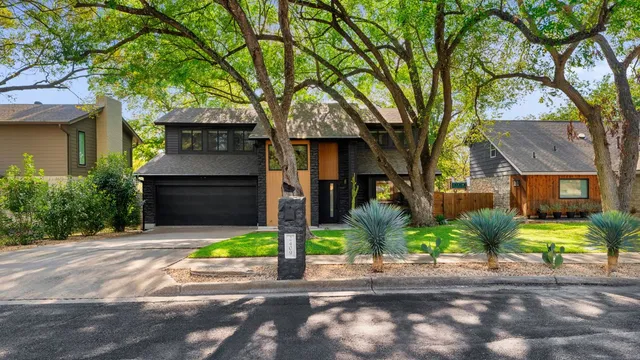 a front view of a house with yard and tree s