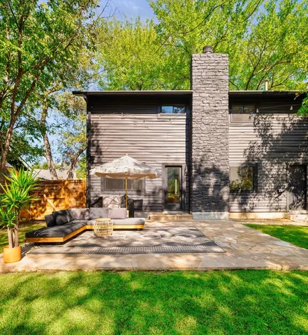 a backyard of a house with table and chairs