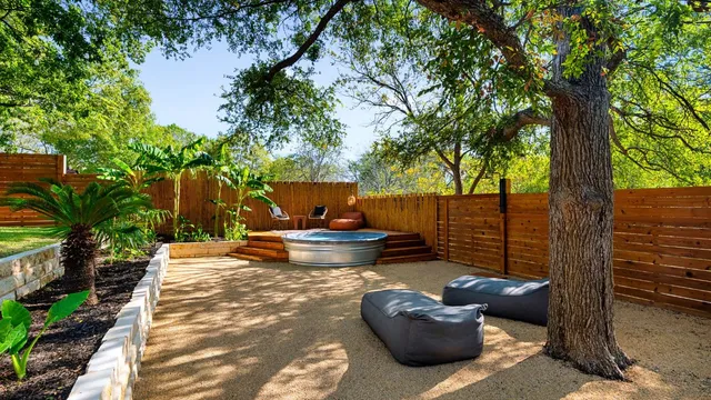 a view of a patio with table and chairs potted plants and a large tree