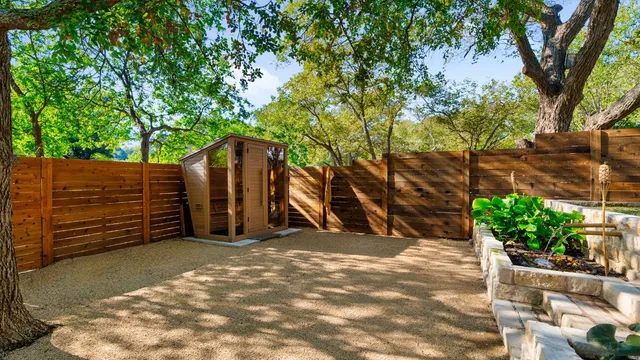 a view of a wooden house with a large tree