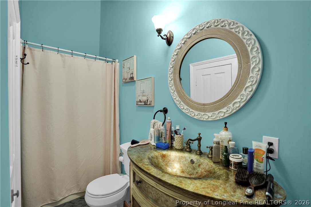 115 North Magnolia Street Raeford, NC 28376 - Photo 12 of 29 a bathroom with a granite countertop toilet sink mirror and vanity