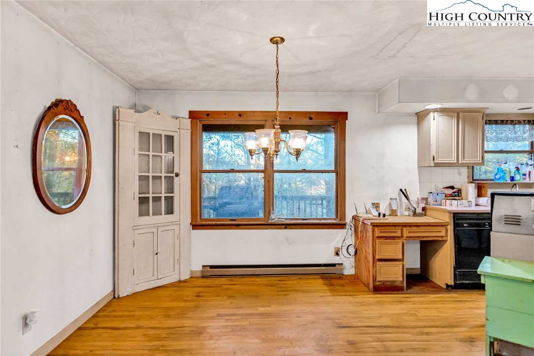 539 Four Coves Trail Crumpler, NC 28617 - Photo 12 of 37 a view of a kitchen with a stove wooden floor and a large window