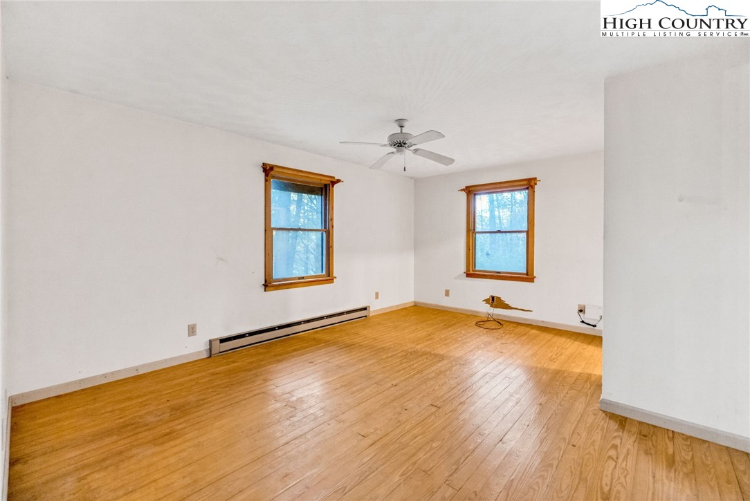 539 Four Coves Trail Crumpler, NC 28617 - Photo 16 of 37 an empty room with a window and a ceiling fan