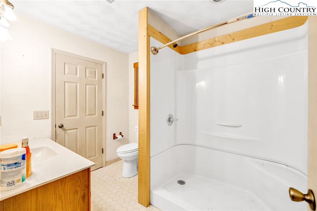 539 Four Coves Trail Crumpler, NC 28617 - Photo 19 of 37 a bathroom with a tub shower vanity and a sink