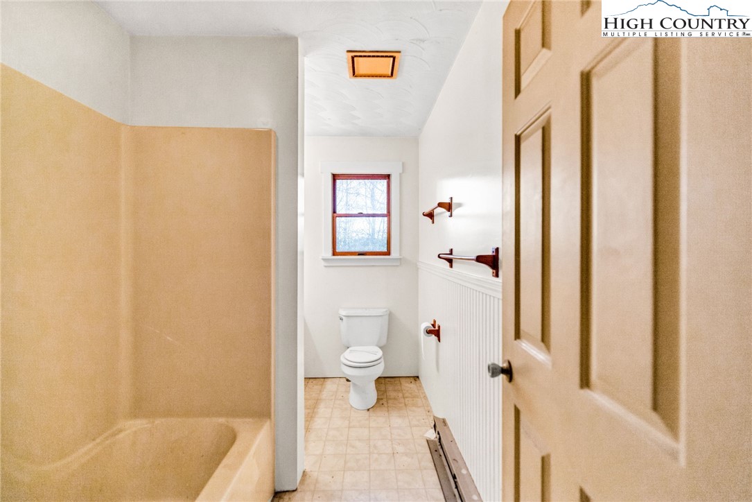 539 Four Coves Trail Crumpler, NC 28617 - Photo 30 of 37 a bathroom with a shower curtain and a toilet
