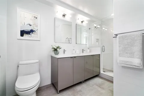 a spacious bathroom with a toilet sink and mirror