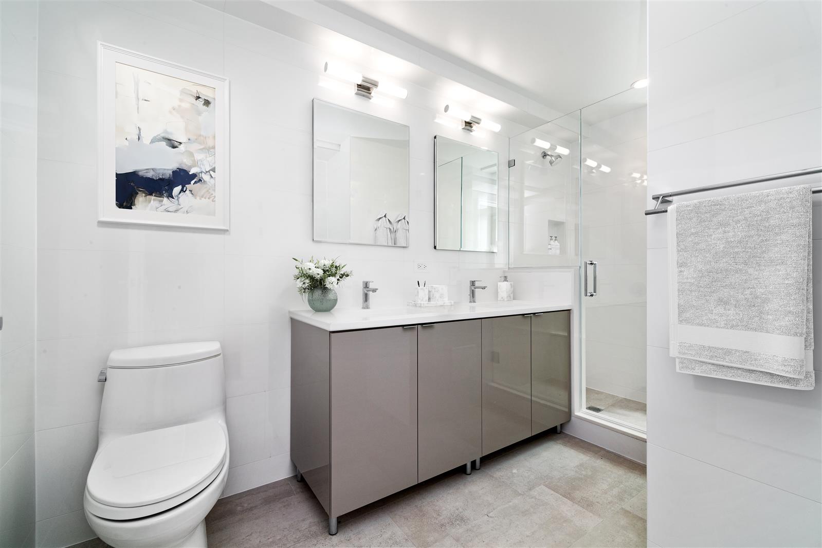 240 Central Park South, Unit 13GH Manhattan, NY 10019 - Photo 18 of 22 a spacious bathroom with a toilet sink and mirror