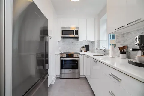 a kitchen with stainless steel appliances a stove sink and microwave