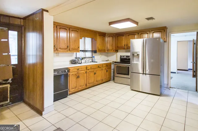 a kitchen with stainless steel appliances granite countertop a refrigerator and a sink