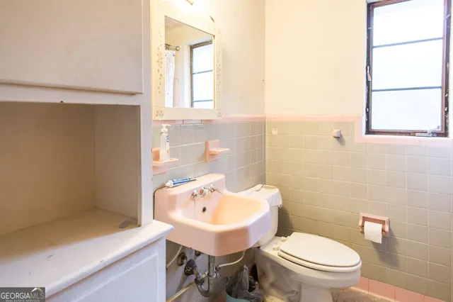 a bathroom with a sink a toilet and mirror