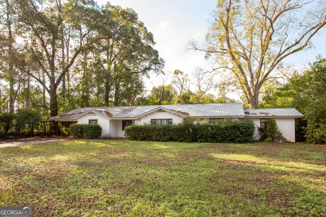 a view of a house with yard and sitting area