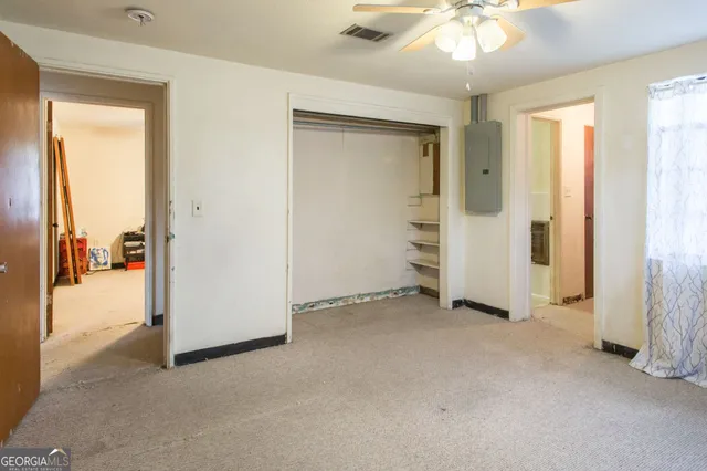 an empty room with windows and closet