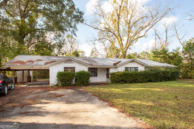 a front view of a house with yard and green space