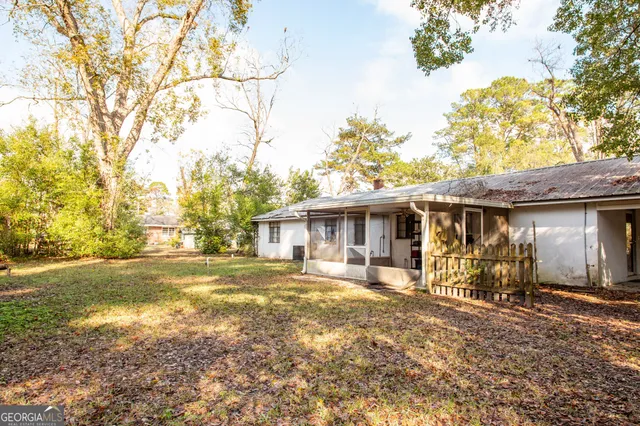 a view of a house with backyard and a tree
