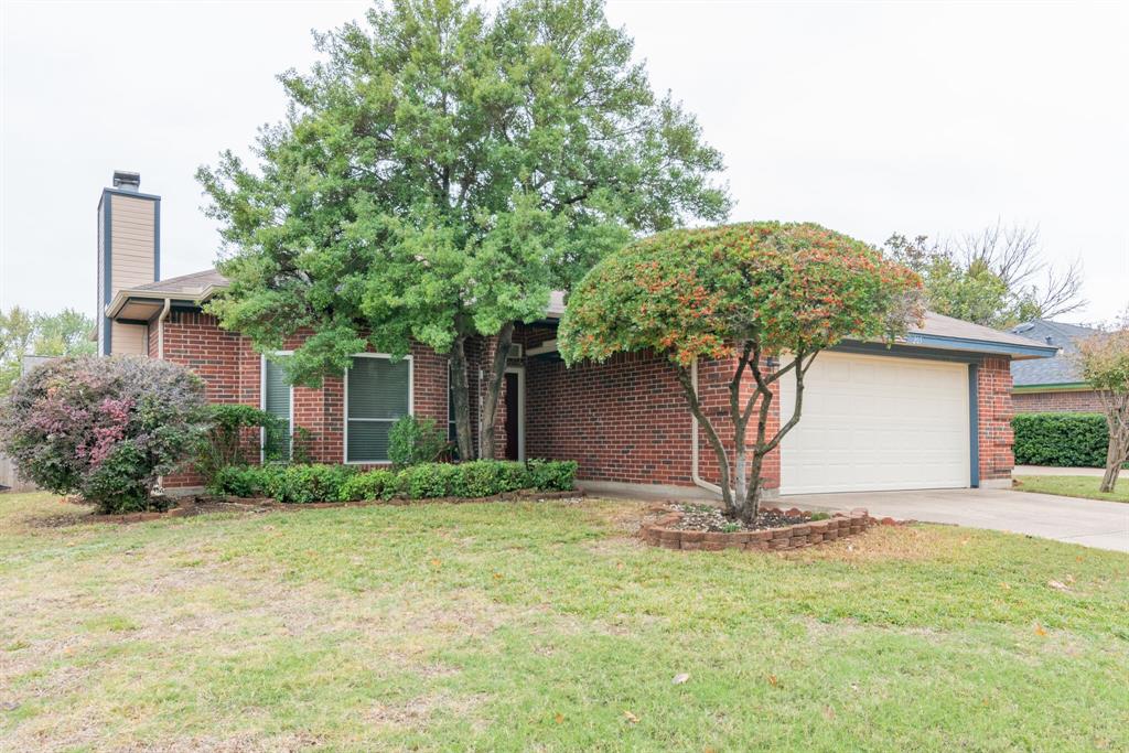 a view of a house with garage and plants