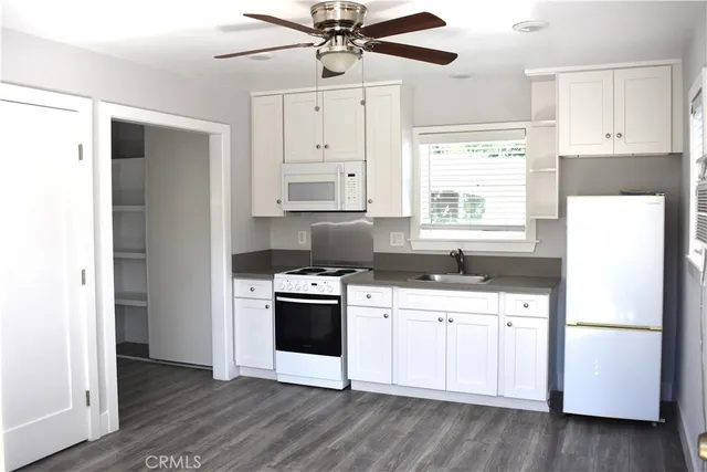 a kitchen with white cabinets and white appliances