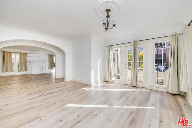 a view of a livingroom with wooden floor and kitchen space