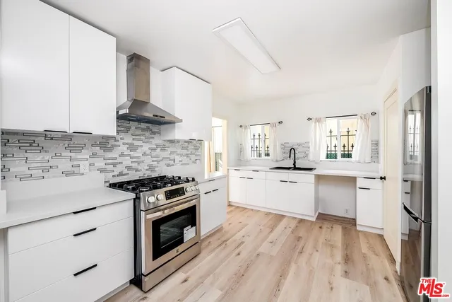 a kitchen with stainless steel appliances a stove sink and refrigerator