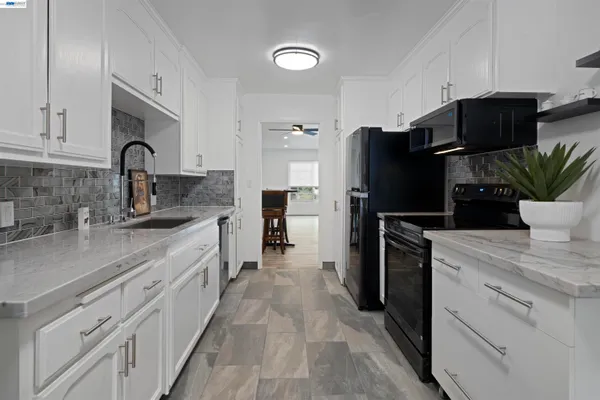 a kitchen with a microwave a refrigerator and a stove top oven