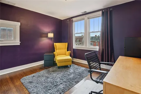 a blue chair sitting in a room next to a window