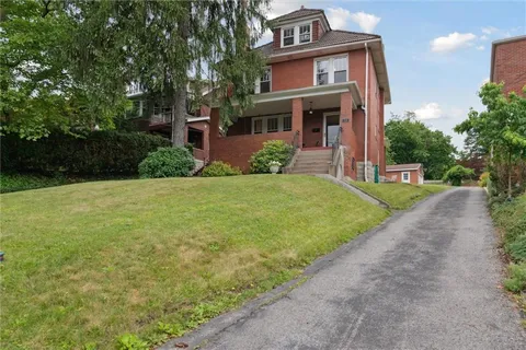 a view of a house with a yard and potted plants