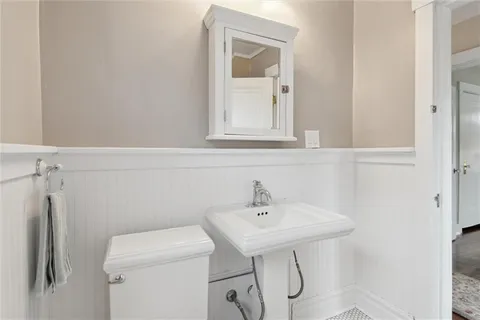 a bathroom with a sink a toilet and a mirror