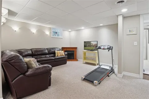 a living room with furniture gym equipment and a ceiling fan