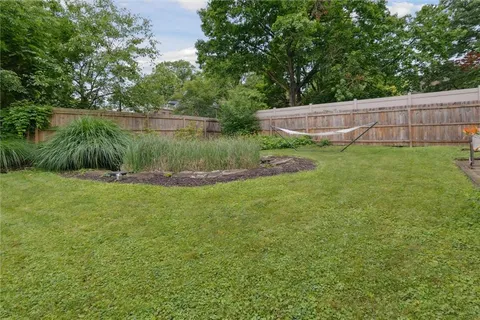 a view of a lake with a yard and a large tree