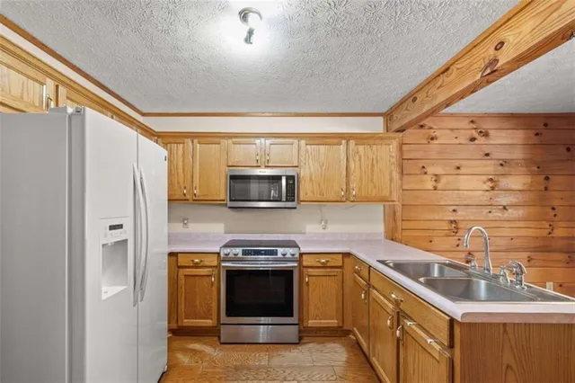 a kitchen with stainless steel appliances a stove sink and microwave