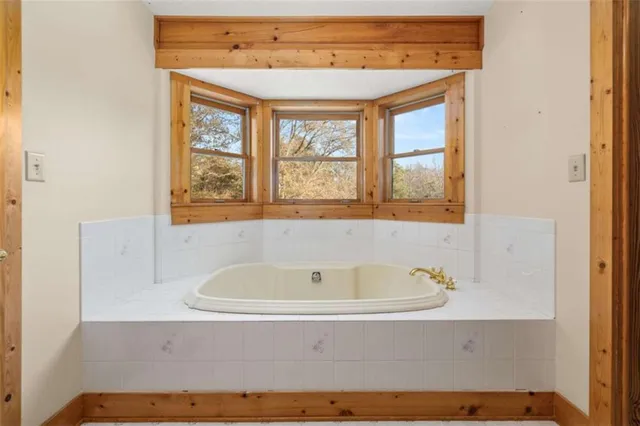 a bathroom with a bathtub and windows