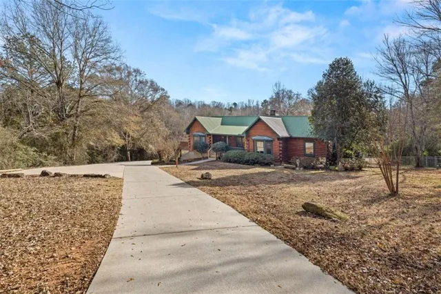 a view of house with wooden floor and large trees