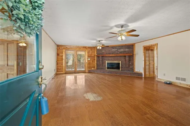 an empty room with fireplace fan and windows