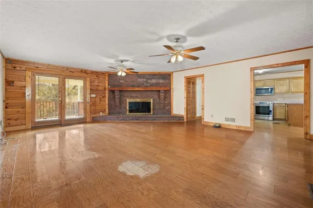 a view of an empty room with a fireplace and a window