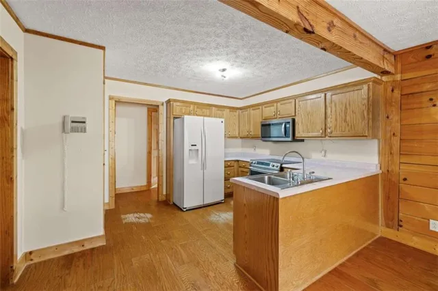 a kitchen with stainless steel appliances granite countertop a refrigerator stove and sink