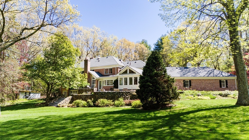 24 Wheeler Road Lincoln, MA 01773 - Photo 3 of 32 a front view of a house with a garden and trees
