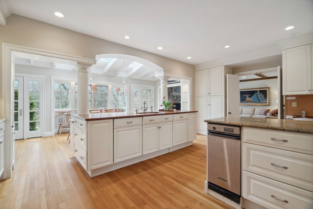 24 Wheeler Road Lincoln, MA 01773 - Photo 6 of 32 a large kitchen with kitchen island white cabinets and wooden floor