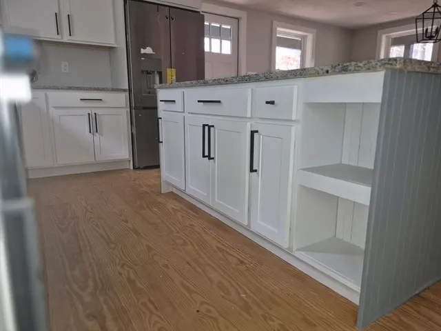 a kitchen with white cabinets and refrigerator